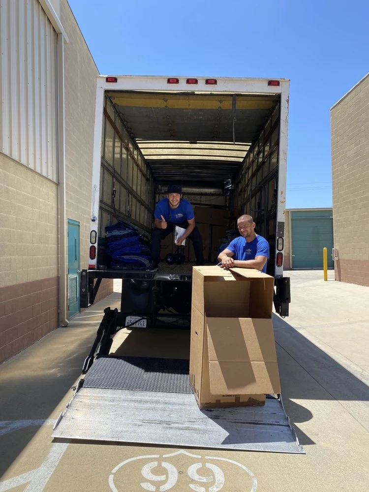 KF Moving movers loading a boxed item into a moving truck